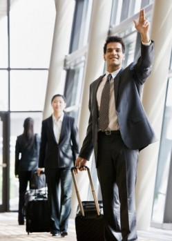 business traveler pulling suitcase. Business Travel Tips from
